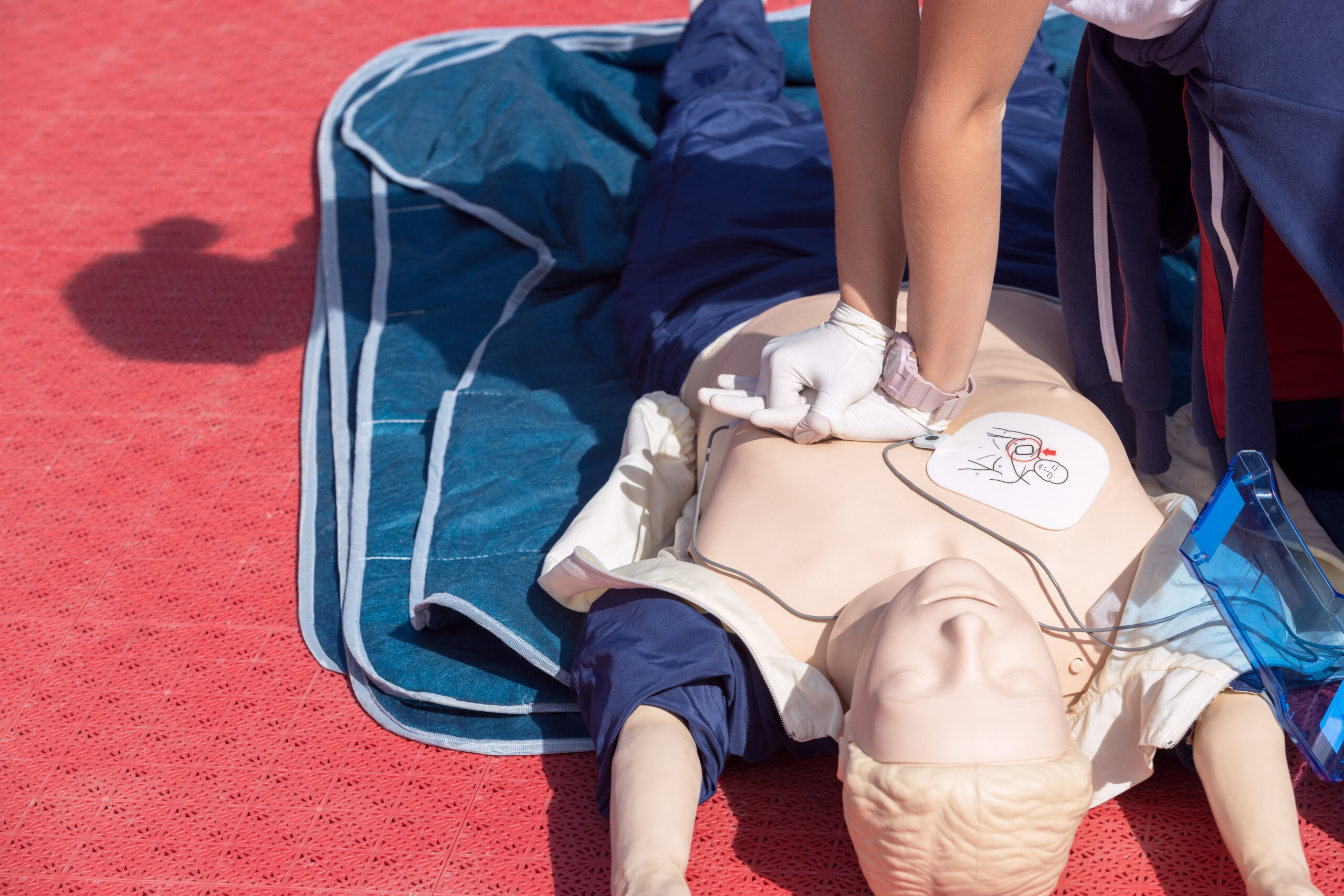 Formation premiers secours BLS-AED en entreprise : massage cardiaque sur mannequin avec défibrillateur
